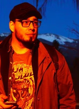 Fernando Martínez Ruppel al atardecer, con gorra y anteojos, frente a montañas nevadas.